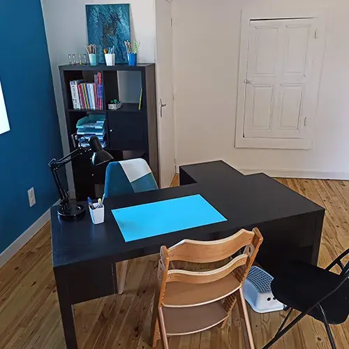 Espace d’accompagnement du cabinet de graphopédagogie avec bureau et chaises adaptées.
